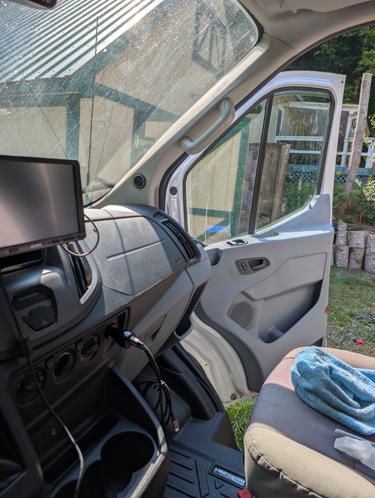 Cab interior from the driver's seat, with the dash cam mirror screen and windshield sunshade in place
