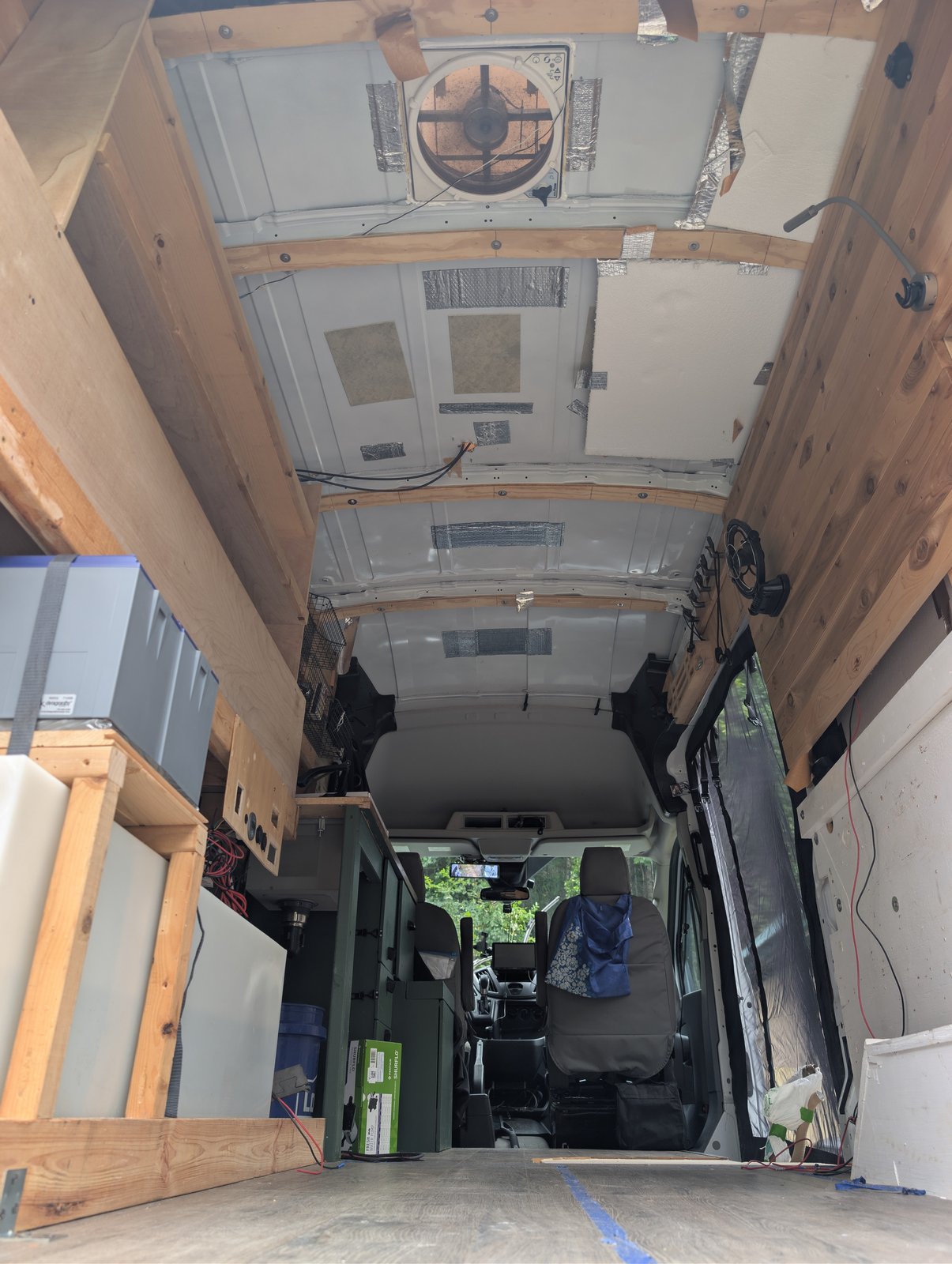 Looking up at the unfinished ceiling with the wooden ribs already fastened in place, and the MaxxAir fan