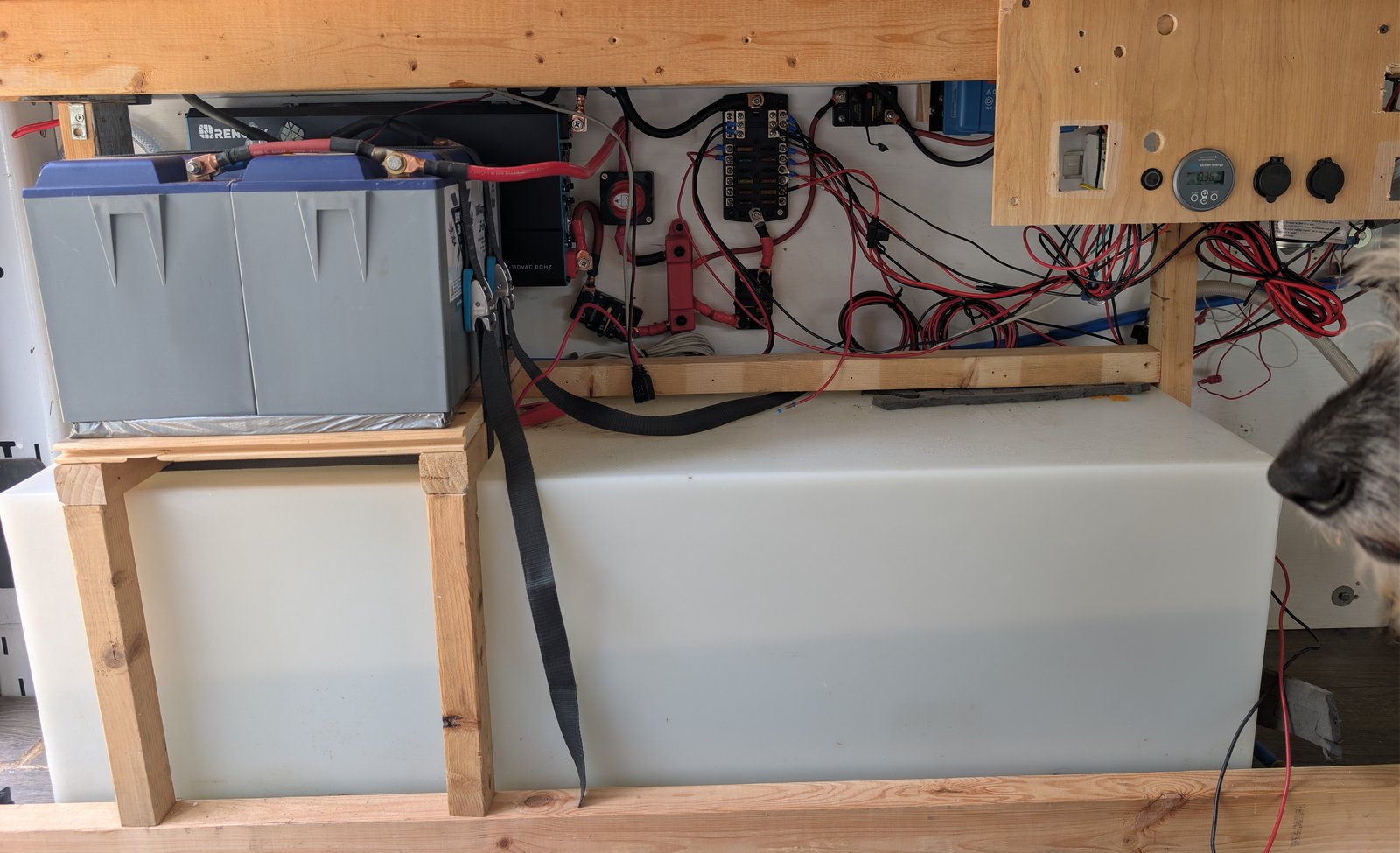 The electrical bay and fresh water tank: inverter, battery, fuse block and monitor above the tank